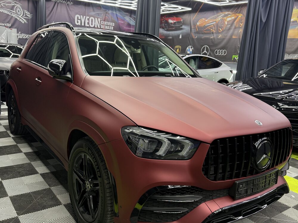 Mercedes-Benz GLE colantat în roșu mat, văzut din față-stânga în atelier