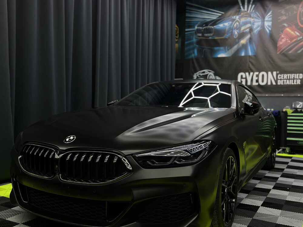 BMW coupe colantat integral în verde foarte închis mat, fotografiat din față-stânga în atelierul Imperial Detailing Oradea
