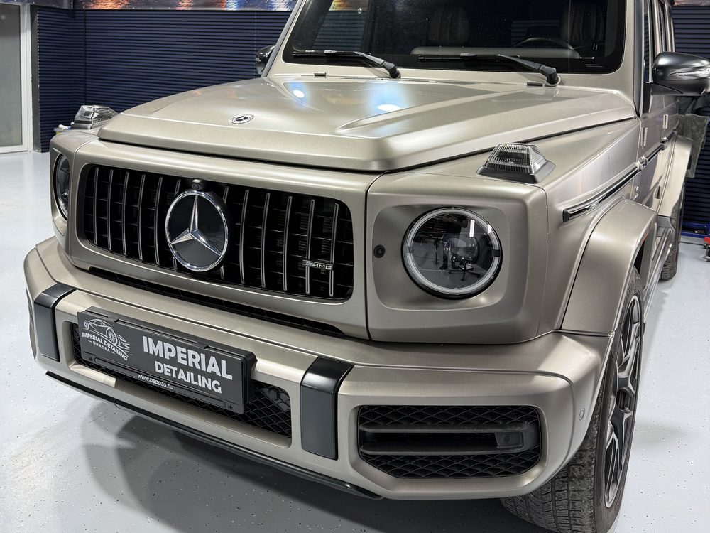 Mercedes-Benz Clasa G în nuanță șampanie mată, văzut aproape frontal, cu plăcuță Imperial Detailing pe bara din față