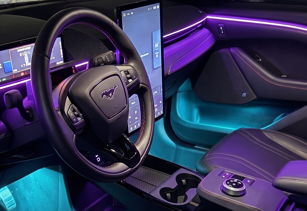 Interior auto cu iluminare ambientală mov montată de Imperial Detailing, cu zona picioarelor turcoaz